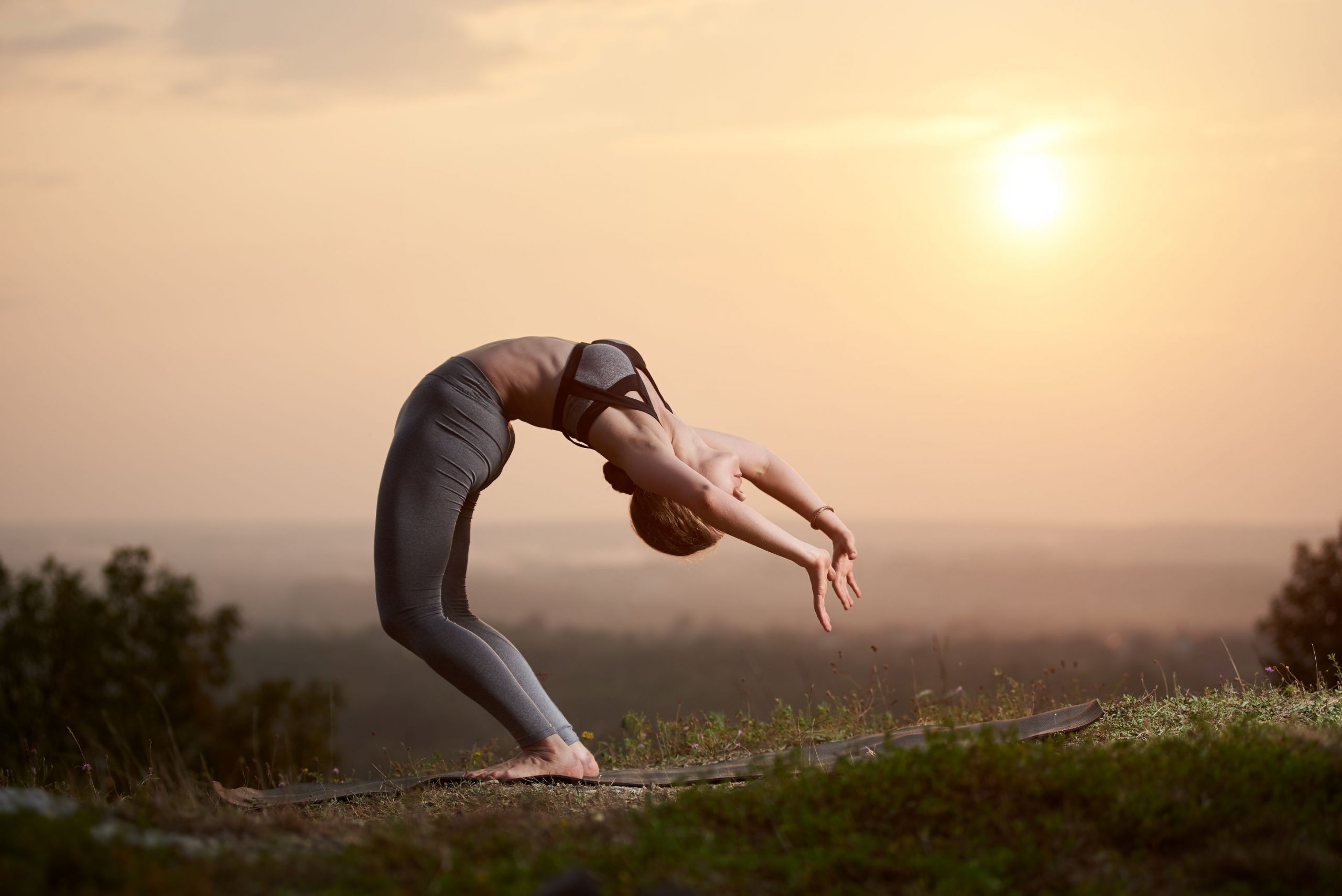 young-woman-doing-yoga-exercises-outdoors-sunset (1)